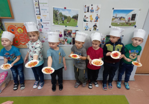 Dzieci prezentują wykonane prace w postaci talerza z makaronem